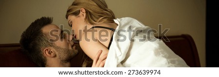 Young passionate couple during foreplay in bed