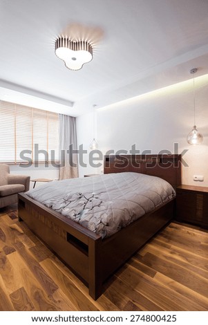Double bed with wooden frame in luxury bedroom