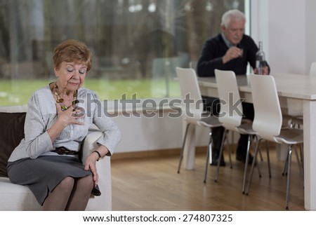 Aged distraught woman and her alcoholic husband