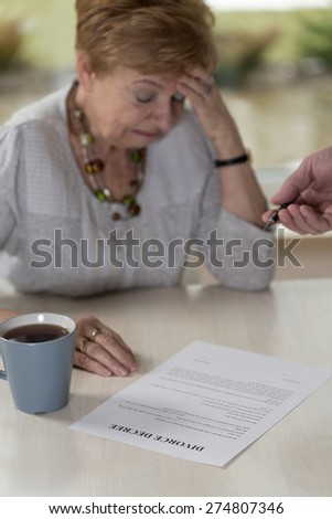 Aged broken down wife crying on divorce decree