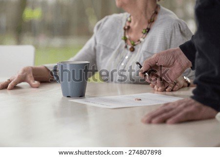 Close-up of elder man signing divorce documents