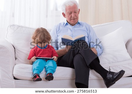 Grandfather and grandchild sitting on the sofa