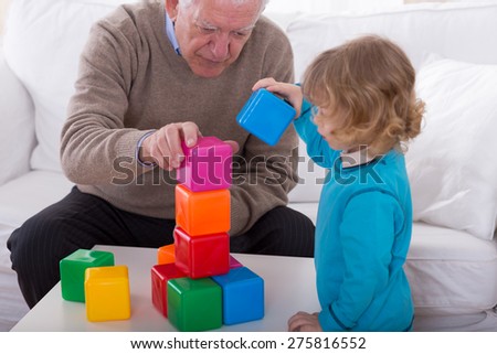 Grandpa and child playing with color cubes