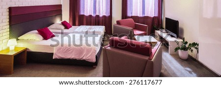 Panoramic photo of violet hotel room with two single beds
