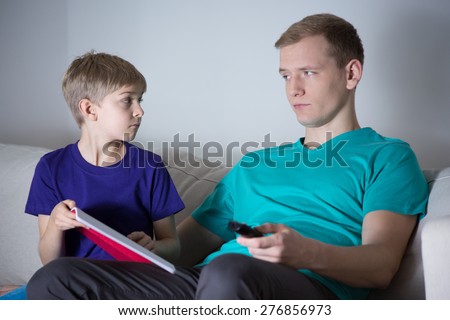 The son asks his father to help him with homework