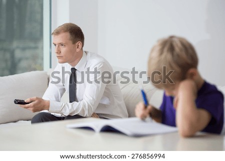 Busy father and bored child sitting in room
