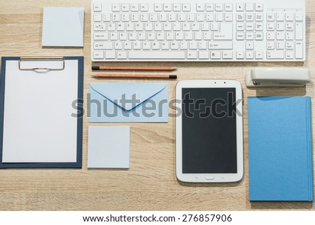 Precisely arranged wooden office desk with tablet and notebook