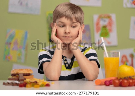 Boy having choice - healthy or unhealthy lunch