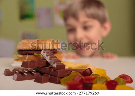 Smiling boy enjoying his unhealthy school lunch