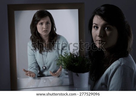 Young woman with mental disorder sitting at the desk