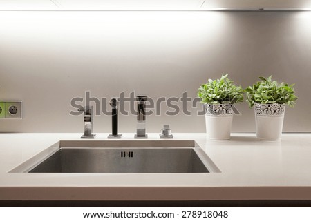 Aluminum sink in kitchen with flowers on wheat