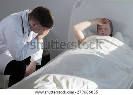 Caring male doctor and young cancer patient