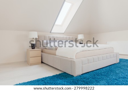 Big double bed in white bright bedroom