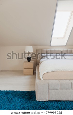 White bedroom with inclined wall and double bed