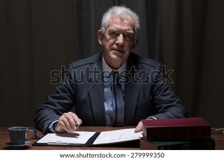 Elderly elegant man sitting alone in his study room