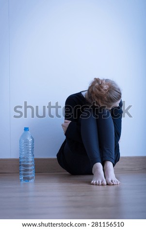 Image of despair anorexic girl drinking only water