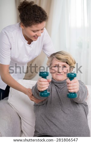Strong older active woman lifting the dumbbells