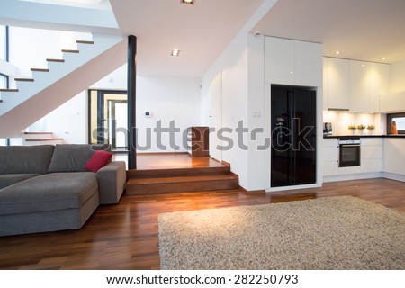 Spacious modern lounge with stairs leading to the first floor