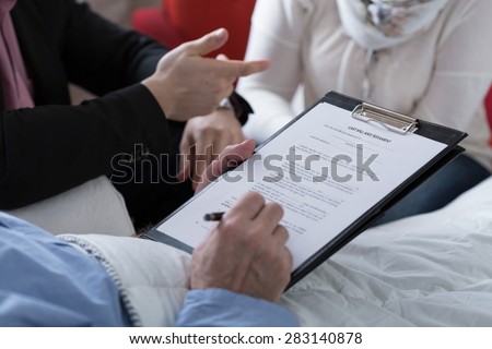 Close-up of older sick man holding his last will and testament