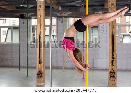 Woman dancing on the pole at the gym