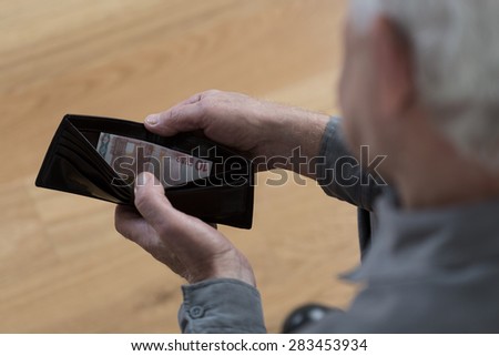 Old man with empty wallet and financial difficulties