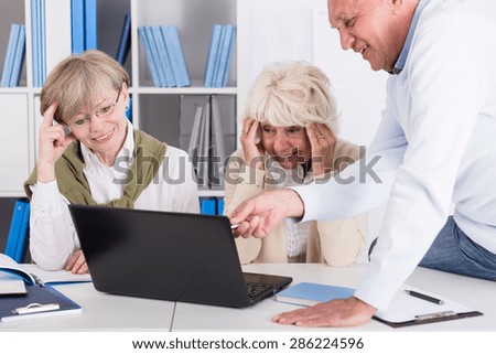 Smiling elder women having problem with computer