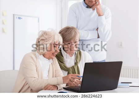 Smiling senior women looking at laptop\'s screen