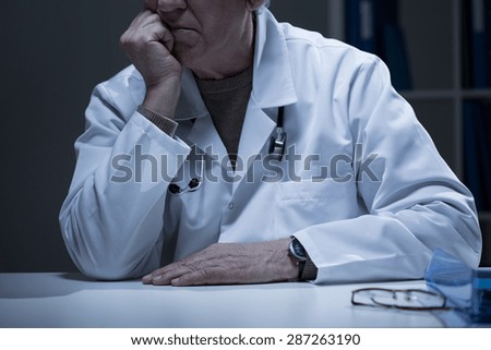 Close-up of man in medical duster sitting in cabinet