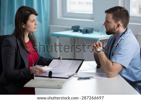 Young afraid doctor meeting with lawyer at his office