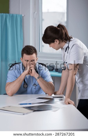 Two young physicians having medical consultation in office