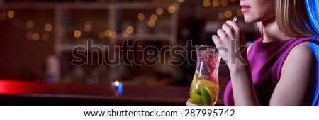 Young girl is drinking delicious coctail in the bar
