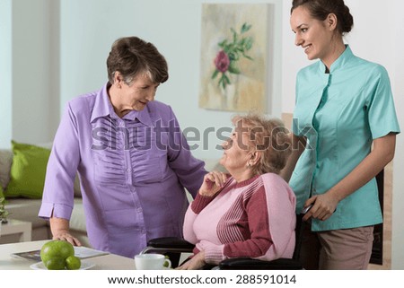 Two older women and young pretty nurse on friendly meeting