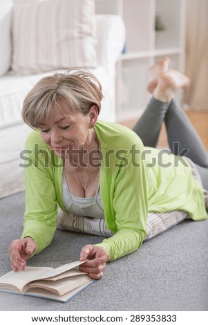 Senior retired woman reading the book in her free time