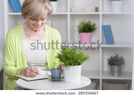 Well organized senior woman with notebook, horizontal