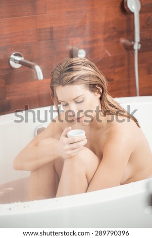 Wet woman smelling oil in the bath