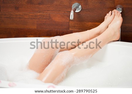 Close-up on legs of young woman in bathtub