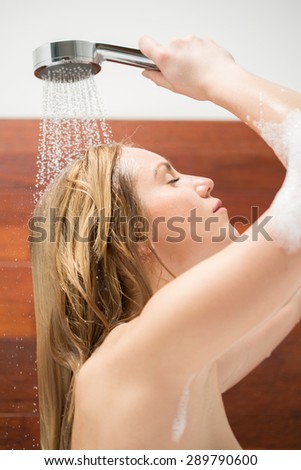 Young woman cleaning her hair during bath