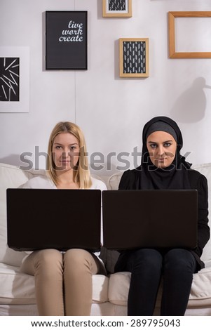 Girls sitting on the sofa with laptops