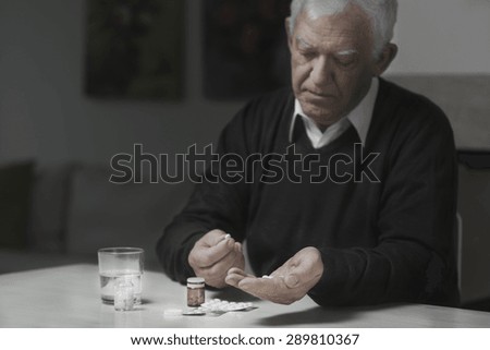 Senior sad man taking a lot of medicines