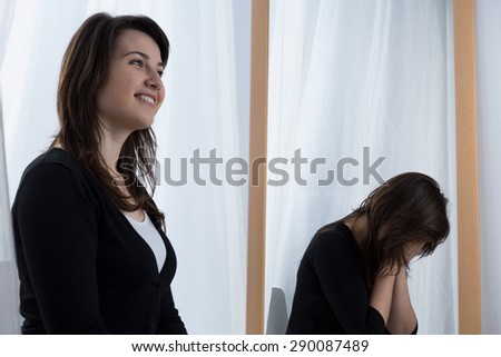 Depressed young woman wearing a fake smile