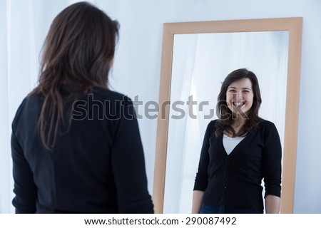Reflection of girl wearing a fake smile
