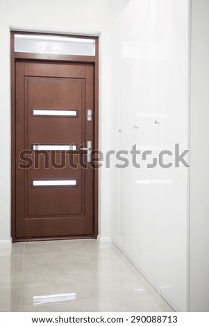 Wooden door in white hall in apartment