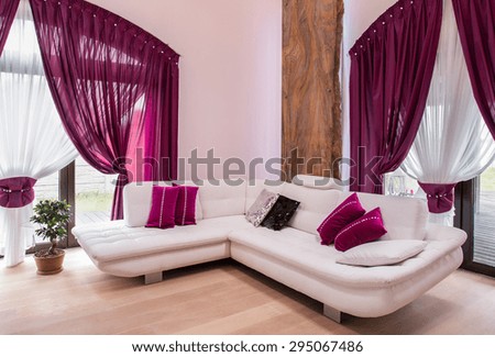 White comfortable corner sofa and rose cushions
