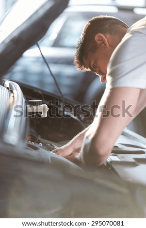Automobile mechanic repairing a car in service station