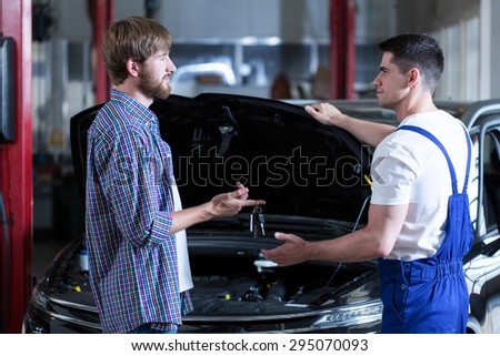 Man giving motor mechanic key to his car