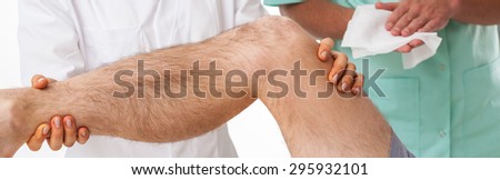 Physical therapist exercising with patient after knee injury
