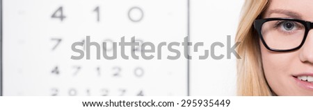 Snellen test and female optician wearing eyeglasses
