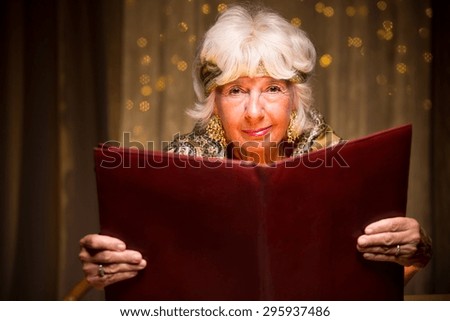 Photo of aged mystique woman holding ancient spell book