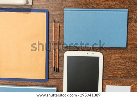 Tablet, books and papers set on wooden desk office