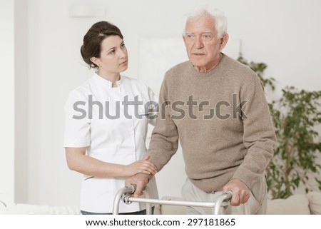 Senior man using walking frame during rehabilitation